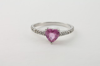 An 18ct white gold dress ring set a heart shaped pink sapphire  supported by diamonds