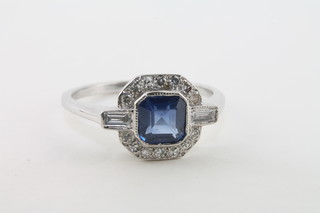 A lady's 18ct white gold dress ring set a square cut sapphire with baguette cut diamonds to the shoulders, supported by diamonds