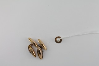 A pair of gold cufflinks together with a gold stud