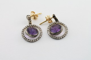 A pair of amethyst and diamond set earrings