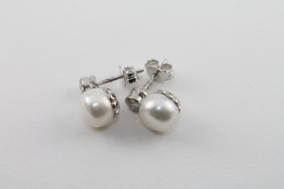 A pair of pearl and diamond set earrings