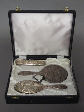 A modern 3 piece silver backed dressing table set comprising  hand mirror, hair brush and clothes brush, cased