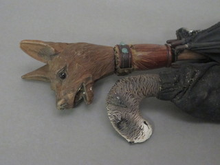 An umbrella with carved wooden handle in the form of a dogs  head together with 1 other umbrella decorated a Terriers head