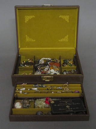 A brown case containing a collection of costume jewellery