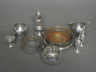 A circular silver plated bottle coaster, a silver plate cream jug  and sugar bowl and a small collection of plated items
