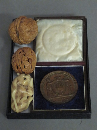 A South London Working Classes Industrial 3rd Class bronze  medal, cased, 2 carved walnuts and a carved Netsuke