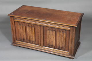 An oak coffer with hinged lid and linen fold decoration 38"