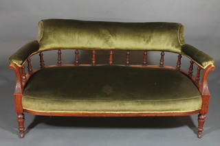 A Victorian walnut show frame sofa upholstered in green  material, raised on turned supports 57"