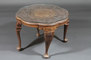 A circular Eastern carved table, raised on cabriole supports 24"