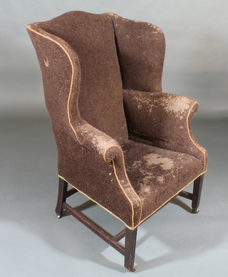 A Georgian mahogany framed winged armchair upholstered in  brown material