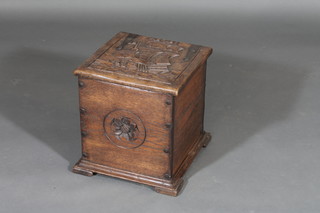 An oak coal box with hinged lid, the lid carved a galleon, raised on bracket feet 14"