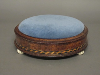 A circular Victorian walnut footstool with upholstered seat,raised on 3 ceramic bun feet 12"