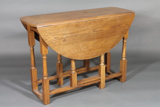 A honey oak oval drop flap gateleg dining table 42"
