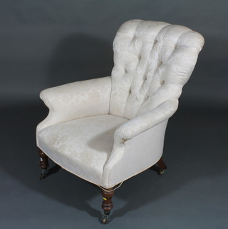 A Victorian mahogany framed armchair upholstered in white material