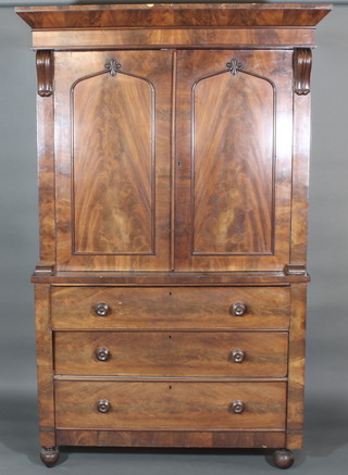 A Victorian mahogany linen press with moulded cornice  enclosed by panelled doors, no trays, the base fitted 3 long  drawers, raised on bun feet 48"