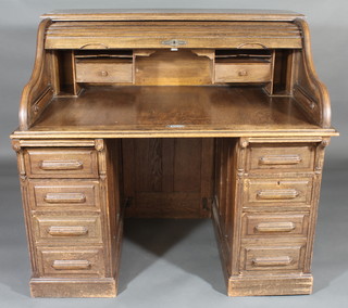 A Victorian oak kneehole pedestal roll top desk with well fitted interior above 1 long and 8 short drawers 48"