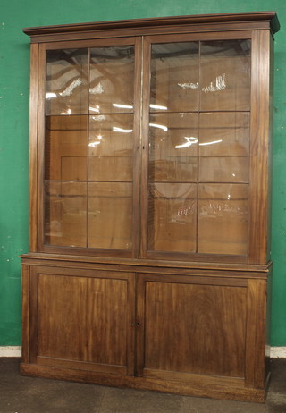 A 19th Century mahogany library bookcase with moulded  cornice enclosed by astragal glazed panelled doors, the base fitted  a cupboard enclosed by panelled doors, raised on a platform base  67"