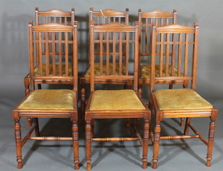 A set of 6 Edwardian mahogany stick and rail back dining chairs  with upholstered seats, raised on turned supports