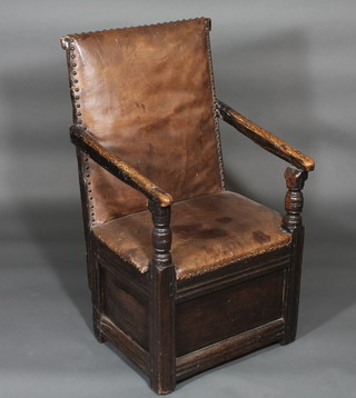 An 18th Century elm open arm chair, the base of panel  construction, the seat and back upholstered in brown leather   ILLUSTRATED