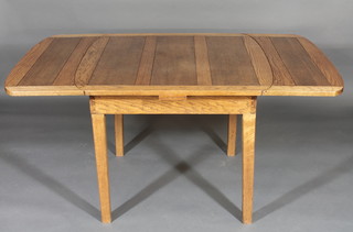 A honey oak drawleaf dining table raised on outstretched  supports 36"