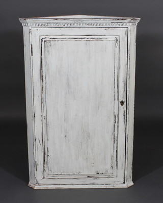 A distressed turquoise painted hanging corner cabinet with  moulded and dentil cornice, the shelved interior enclosed by a  panelled door 27"