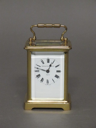 A 20th Century 8 day carriage clock with enamelled dial and Roman numerals, contained in a gilt metal case