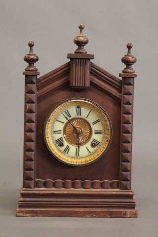 An American mantel clock with enamelled dial and Roman  numerals contained in a pine architectural style case 10"