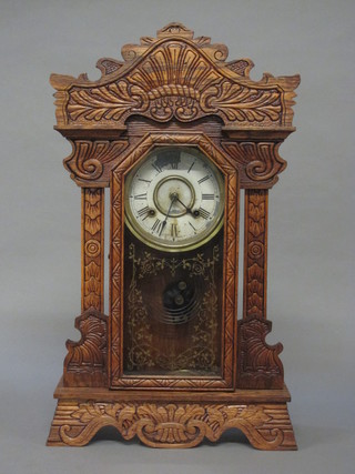 An American striking mantel clock with painted dial and Roman numerals contained in a carved oak case by the Newhaven Clock  Co.
