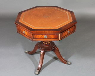 A Georgian style octagonal inlaid mahogany drum table inset a  brown leather surface, raised on pillar and tripod supports, 25"