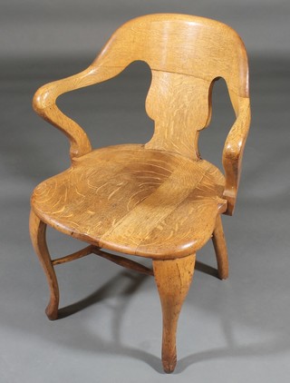 A honey oak tub back open arm chair, raised on cabriole supports