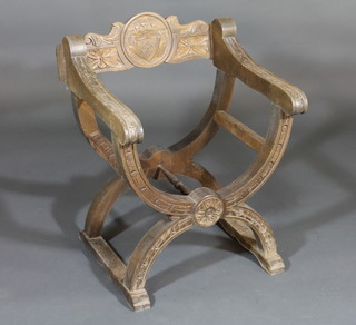 A carved oak X framed chair