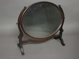 A 19th Century oval plate dressing table mirror contained in a mahogany swing frame 21"