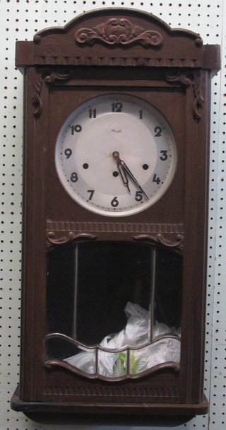 A 1930's chiming wall clock with silvered dial and Arabic  numerals contained in an oak case