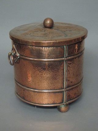 A planished copper coal bin raised on bun feet 12"