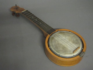 A 4 stringed banjo, the neck marked Keech