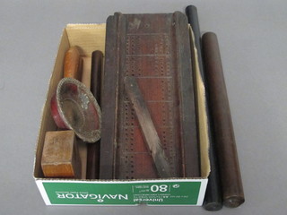 A wooden cribbage board, various wooden rolling rulers and  other items of treen