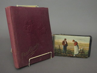 A red card album of various postcards, souvenir postcards of Alexandria, Jerusalem and 3 small postcard albums