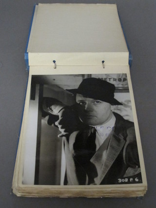 A blue fabric album containing a collection of black and white photographs of film stars