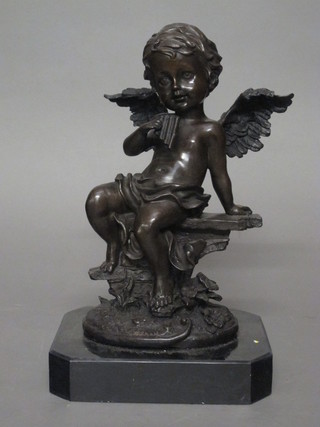 A bronze figure of a seated cherub with pan pipes, raised on a black marble base 14"