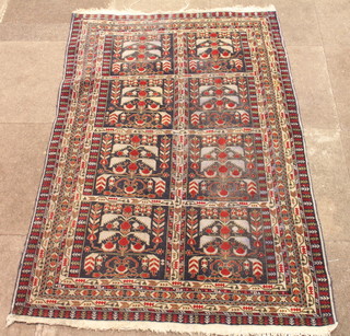 A Persian rug with 8 floral panels to the centre within multi-row borders 59" x 39"
