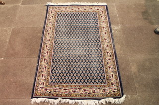 A blue ground Persian rug with paisley design to the centre  within multi row borders 59" x 37"