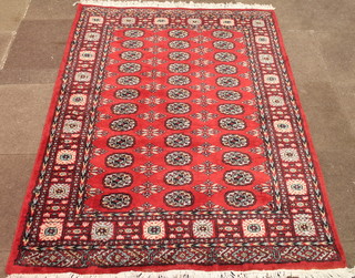 A red ground Bokhara rug with 36 octagons to the centre 74" x  55"
