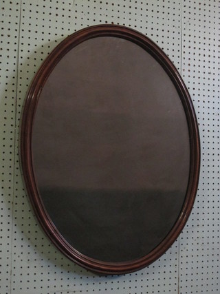 A 19th Century oval plate wall mirror contained in a walnut frame 28"