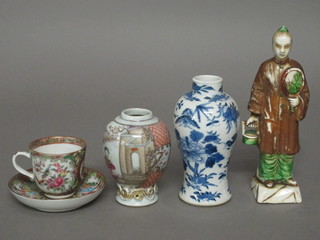 A Canton famille rose cup and saucer 2", Oriental club shaped vase 4", Oriental blue waisted vase 5" and a standing Oriental  figure of a gentleman