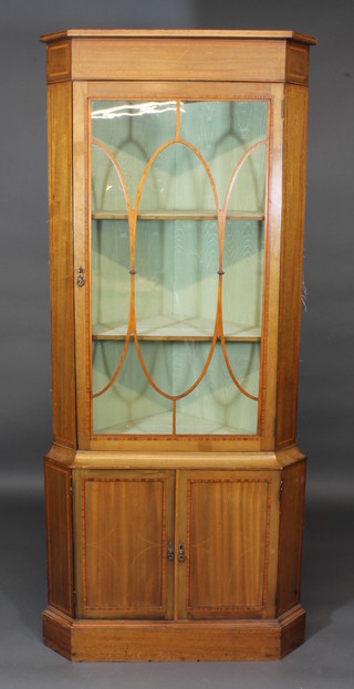 A 19th Century inlaid mahogany double corner cabinet with  moulded cornice, the upper section fitted shelves enclosed by  astragal glazed panelled doors, the base fitted a cupboard  enclosed by panelled doors, raised on a platform base 34"