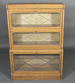 A honey oak 3 tier Globe Wernicke style bookcase enclosed by  panelled doors, 33"