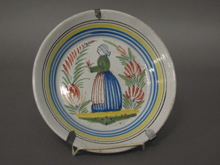 A circular Quimper ware plate decorated a lady, cracked, 8 1/2"
