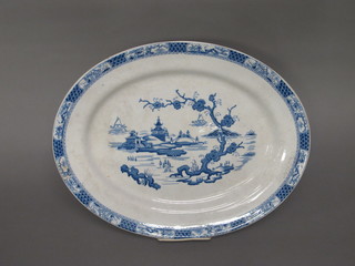 An oval blue and white pottery meat plate with stylised Willow  pattern 18"