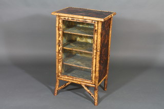 A bamboo cabinet with shelved interior enclosed by  glazed panelled doors, 21"