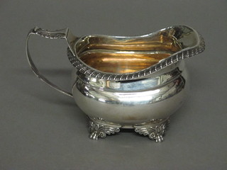 A Georgian silver cream jug with wavy border, raised on panel supports, London 1781, marks rubbed, 4 1/2 ozs